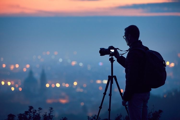 A photographer shooting the landscape at night with the help of a tripod